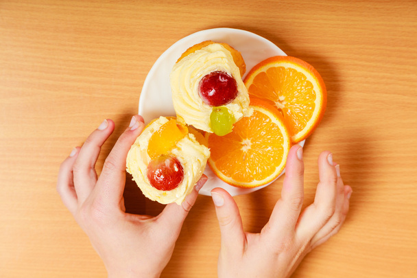 Hands take gourmet cream cake cookie and orange - Zdjęcie, obraz