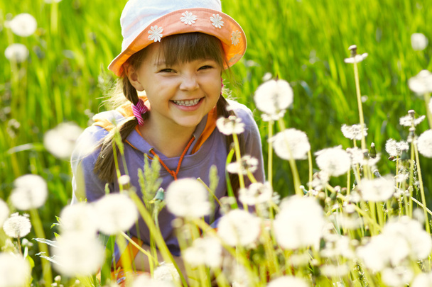 Smiling girl in a field of dandelions - Foto, imagen
