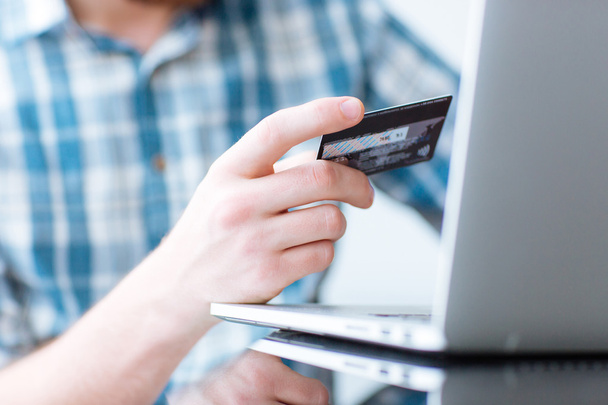 Man shopping online on laptop computer with credit card - Fotó, kép
