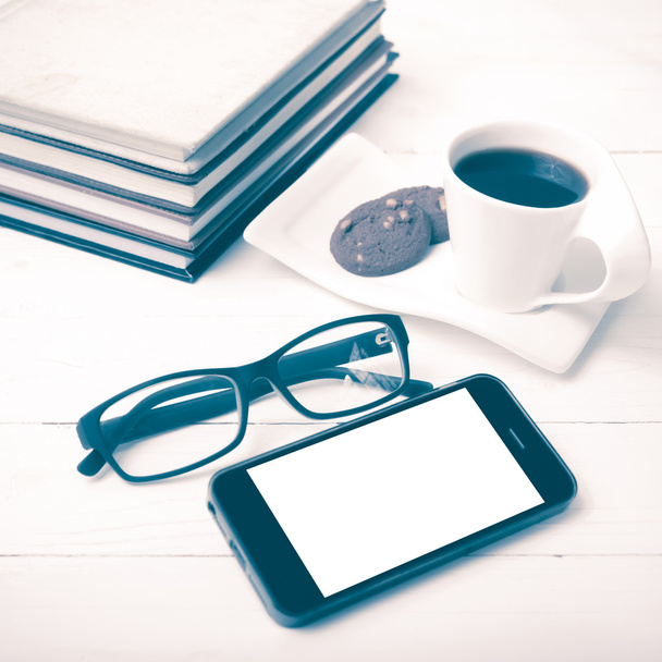 coffee cup with cookie,phone,stack of book and eyeglasses vintag - 写真・画像