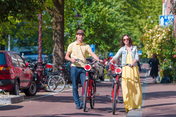 Молода щаслива подружня пара кавказьких велосипедів на старих вулицях Амстердама. - Фото, зображення