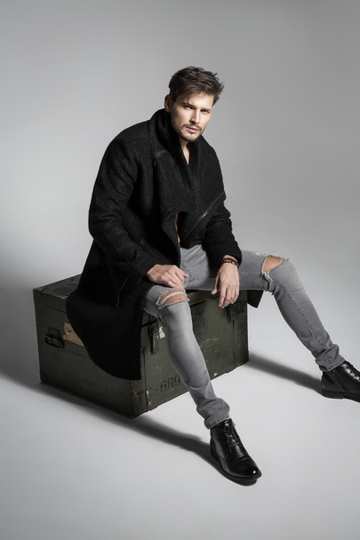 Handsome male model posing in black coat - Фото, зображення