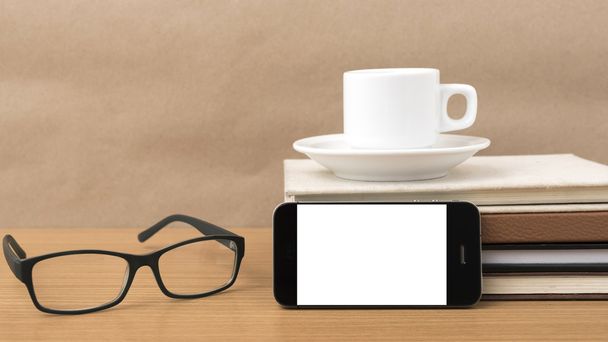 kahvi, puhelin, kirjapino ja silmälasit
 - Valokuva, kuva