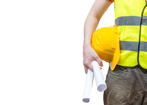 Werknemer (ingenieur) in geel reflecterend vest houdt papieren. Geïsoleerd op witte achtergrond. - Foto, afbeelding
