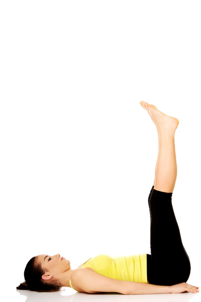 Fitness woman with her legs up. - 写真・画像