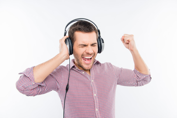 Cheerful man in headphones listening music and gesturing  - Foto, afbeelding