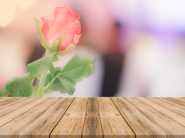 Деревянная доска пустой стол перед размытым фоном. Перспективы коричневого дерева над размытыми красивыми розами - может быть использован для отображения или монтажа вашей продукции и макет
. - Фото, изображение