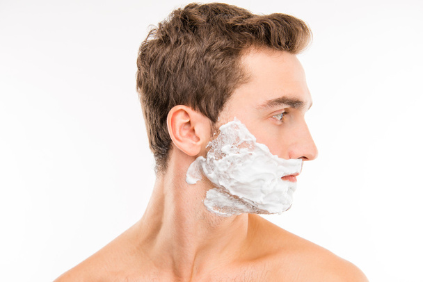 A side-view portrait of young man with shaving foam - Foto, Bild