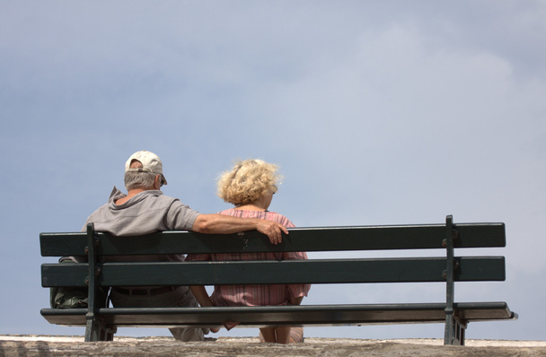 bejaarde echtpaar zittend op een bankje - Foto, afbeelding
