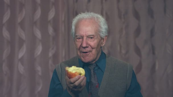Soddisfatto e sorridente nonno morde una mela
. - Filmati, video