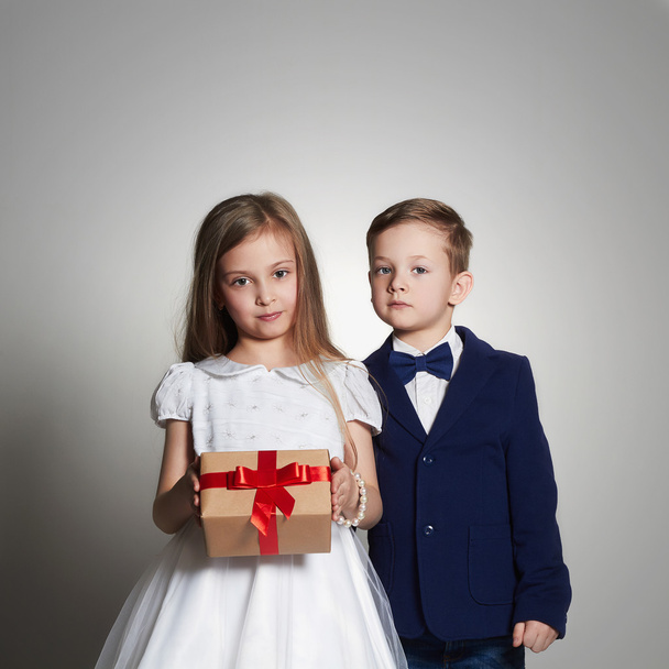 hermosa pareja divertida con un regalo en una caja. La hermosa niña y el niño juntos. niños
 - Foto, imagen