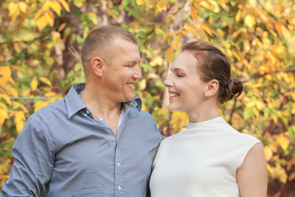 Happy husband embracing wife in autumn park - Foto, Bild