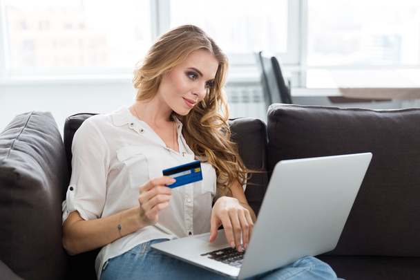 Happy woman making purchases in internet using credit card  - 写真・画像