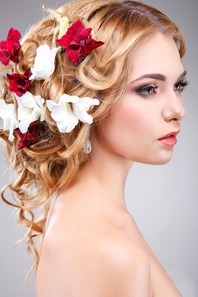 Beautiful  girl with varicoloured flowers - Фото, зображення