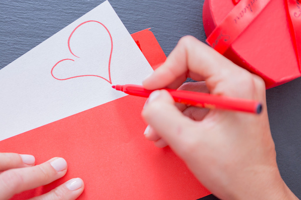 Pictured heart on paper sheet sticking out of envelope - Фото, изображение