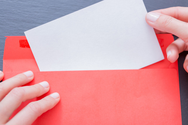 Vrouw met papier vel steken uit envelop - Foto, afbeelding