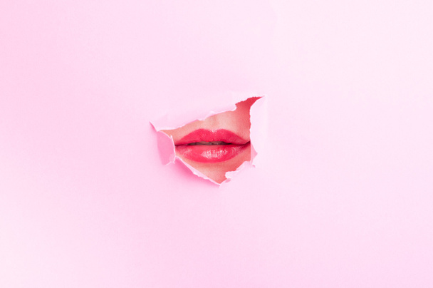 Woman mouth with red lips thru torn cardboard  - Zdjęcie, obraz