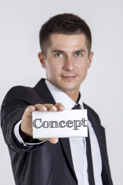 コンセプト - テキスト付きの白いカードを持つ若いビジネスマン - 写真・画像