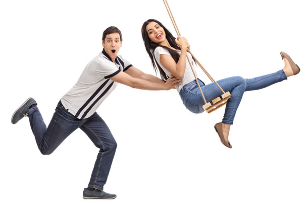 man pushing his girlfriend on a swing - Zdjęcie, obraz