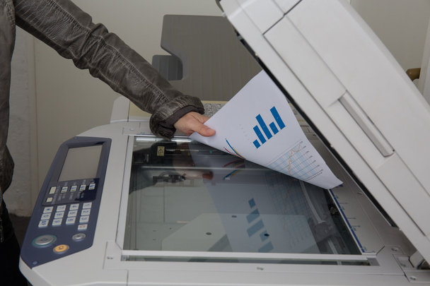 Vrouw enkele documenten aan het werk op een kopieermachine scannen - Foto, afbeelding
