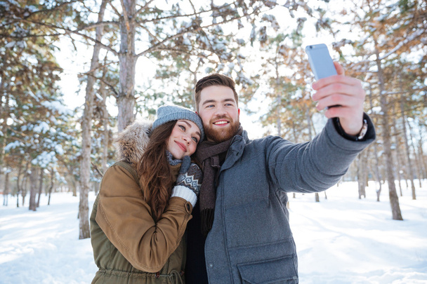 Couple making selfie photo in winter park - Fotografie, Obrázek