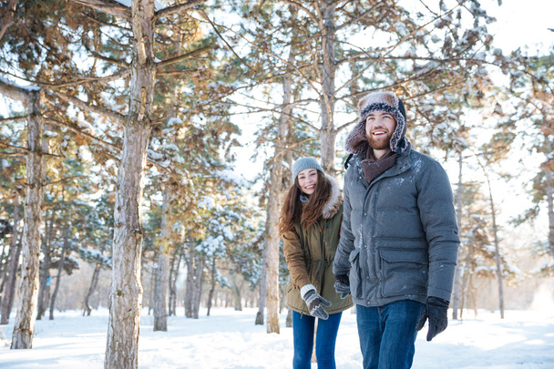 Beautiful happy couple in winter clothes walking outdoors - 写真・画像