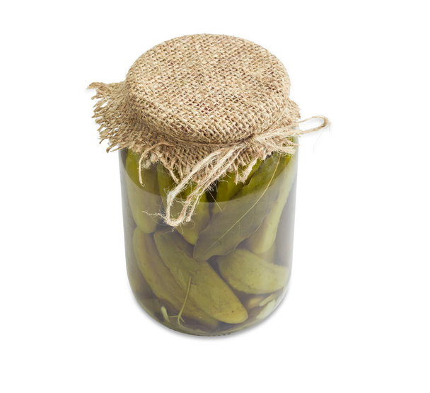 Pickled cucumbers in glass jar on a light background - Fotó, kép