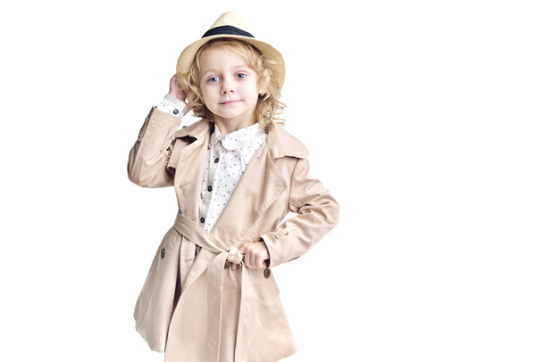 Fashionable child. Blonde girl in a stylish raincoat and hat. - Foto, afbeelding