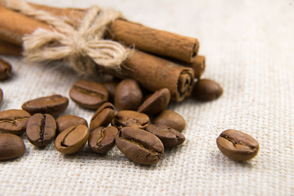 Muitos dos grãos de café torrados e canela na toalha de mesa
 - Foto, Imagem