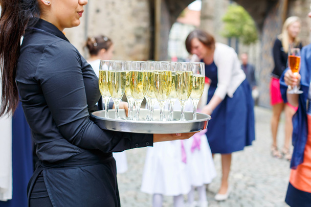 σερβιτόρα με πιάτο ποτήρια σαμπάνιας και κρασιού - Φωτογραφία, εικόνα