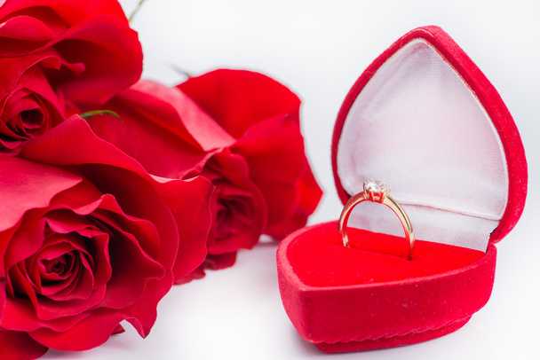 ゴールデン リング (浅い自由度を持つ赤いバラと赤のベルベット ボックスのクローズ アップ) - 写真・画像