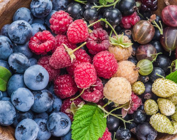 Ripe berries in the wooden bowl. - Foto, Bild