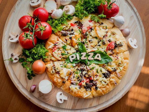 pedaços de pizza com letras de madeira e tomates
 - Foto, Imagem