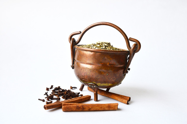 Copper pot of guarana with some cloves and cinnamon near it - Fotografie, Obrázek