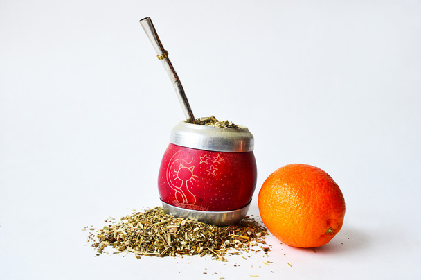 Hand-made mate cup full of guarana, metallic tube for drinking and a mandarin - Fotografie, Obrázek