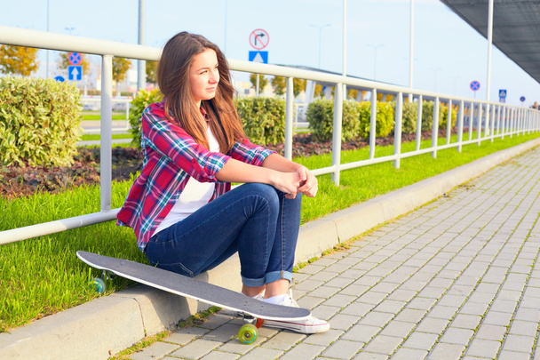 mooie jonge vrouw met een skateboard - Foto, afbeelding