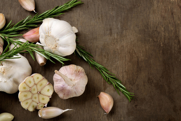 Composition of garlic and rosemary on wooden background - Fotoğraf, Görsel