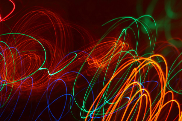Coloridos rayos de luz dibujando los patrones abstractos en la oscuridad
 - Foto, Imagen