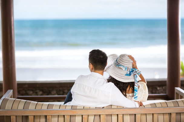 Abrazando a la pareja disfrutando de la vista del azul del mar
 - Foto, imagen