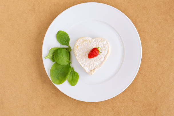 strawberries and cheese in the shape of hearts and spinach - Photo, Image