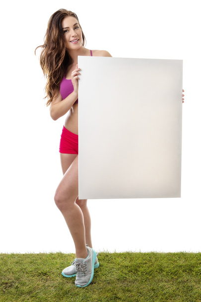 Fitness woman holding large blank paper sign. - 写真・画像