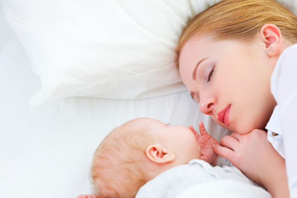 生まれたばかりの赤ちゃんと母親が一緒に寝て - 写真・画像
