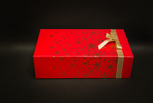 暗い灰色の背景に分離されたクリスマス赤ギフト ボックスのクローズ アップ ビュー - 写真・画像
