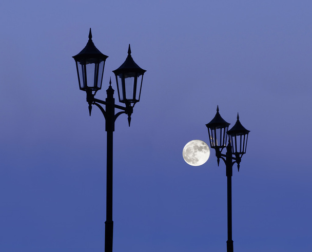 postes de lámpara en el cielo púrpura con luna llena
 - Foto, Imagen