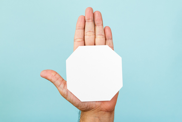 Stop hand and octagon shape on blue background - Photo, Image