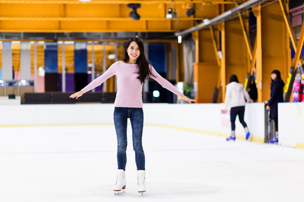 Asian woman skating on ice rink - Fotoğraf, Görsel