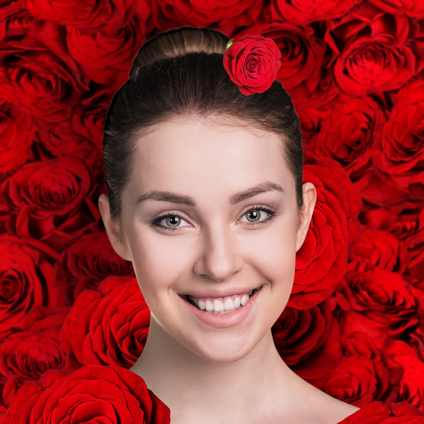 Woman face on the red roses background - Fotoğraf, Görsel