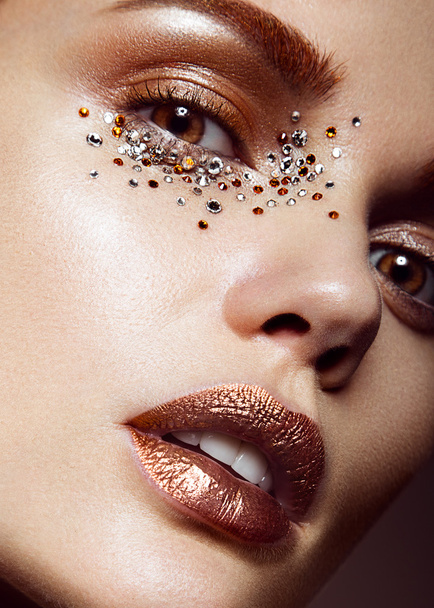Beautiful girl with a gentle make-up and crystals on the face. Close-up portrait. - Foto, afbeelding