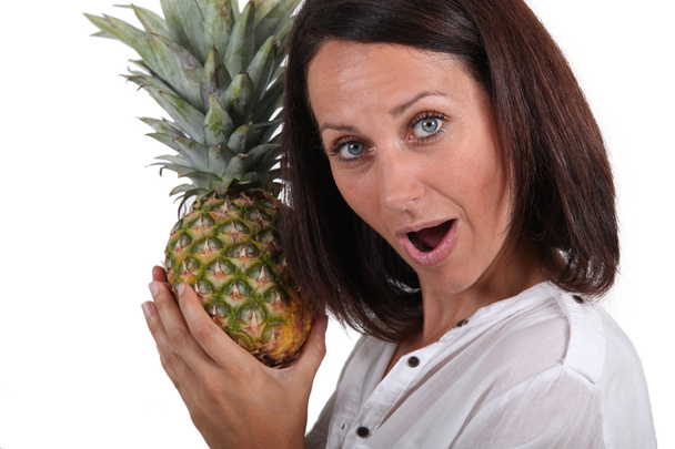 Portrait of a woman holding a pineapple - Photo, Image