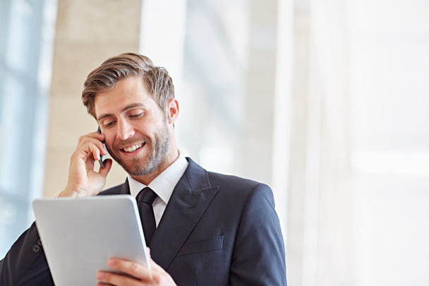 businessman speaking on phone and using tablet - Фото, зображення